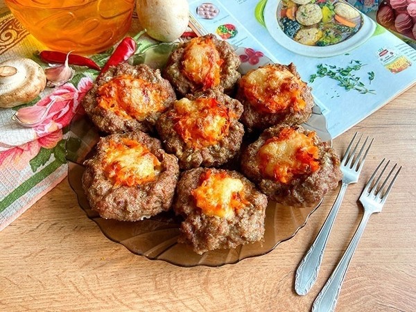 Мясные гнезда с сыром и овощами 

Необходимые ингредиенты:
- Фарш говяжий – 600 г.
- Помидоры – 200 г.
- Сыр твёрдый – 100 г.
- Лук среднего размера – 1 шт.
- Яйцо куриное – 1 шт.
- Крупа манная – 2 ст. л.
- Базилик сухой – по вкусу.
- Соль и перец – по вкусу.

Процесс приготовления:
Говяжий фарш следует выложить в глубокую миску и соединить с манкой. Это блюдо также можно готовить из свиного фарша или любого другого, какой вам по вкусу; После этого в миску с фаршем нужно вбить яйцо, предварительно вымыв его. Добавьте сухой базилик и перемешайте. Можно заменить куриное яйцо 2-3 перепелиными, с ними блюдо будет более полезным в части витаминов и железа; По своему вкусу добавьте соль. Предпочтительнее брать крупнозернистую соль, она полезнее; Хорошо перемешайте фарш, можете даже слегка отбить, чтобы он стал более густым; На сковороде разогрейте растительное масло и отправьте обжариваться измельченный лук, а также натёртую крупной стружкой морковку; Когда овощи станут мягкими, добавьте в сковороду измельченный чеснок. Можно добавить дольку или две, по своему вкусу; Измельчите помидоры – в нашем случае использованы замороженные томаты – и добавьте на сковороду к луку и моркови. Тушите 3 минуты; На противень постелите пергаментную бумагу и смажьте растительным маслом. Из фарша сформируйте шарики и выложите их на расстоянии друг от друга, поле этого стаканом сделайте углубление в каждом; В углубления гнезд поместите овощную начинку; Сыр нужно натереть и обильно посыпать сверху на гнезда. Поставьте на полчаса в духовой шкаф, разогретый до 180 градусов на полчаса.